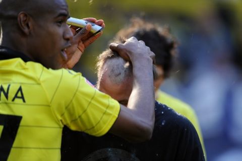 RESTRICTIONS / EMBARGO - ONLINE CLIENTS MAY USE UP TO SIX IMAGES DURING EACH MATCH WITHOUT THE AUTHORISATION OF THE DFL. NO MOBILE USE DURING THE MATCH AND FOR A FURTHER TWO HOURS AFTERWARDS IS PERMITTED WITHOUT THE AUTHORISATION OF THE DFL.Dortmund's striker Kevin Grosskreutz (R) gets his hair cut by teammate Brazilian defender Felipe Santana after the German first division Bundesliga football match Borussia Dortmund vs 1.FC Nuremberg in Dortmund, western Germany, on April 30, 2011. Borussia Dortmund were crowned Bundesliga champions with a 2-0 win at home against Nuremberg to land their first German league title since 2002. AFP PHOTO / PATRIK STOLLARZ (Photo credit should read PATRIK STOLLARZ/AFP/Getty Images)