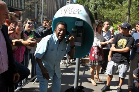 Brazilian football legend Pele autographs a phone booth at Paulista Avenue, in Sao Paulo, Brazil on May 8, 2014 as part of an advertising campaign for a telephone company. Photo: Sergio Castro/Estadao Conteudo.