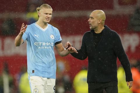 Manchester City's head coach Pep Guardiola talks to Manchester City's Erling Haaland after the English Premier League soccer match between Manchester United and Manchester City at Old Trafford stadium in Manchester, England, Sunday, Oct. 29, 2023. (AP Photo/Dave Thompson)