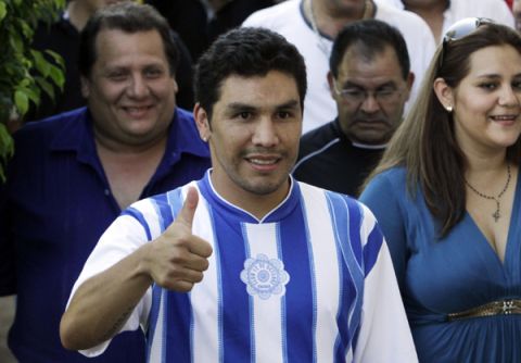 Paraguayan striker Salvador Cabanas (L) gestures as he arrives for his presentation to the media as a player of the third division "12 de Octubre" club in Itaugua, near Asuncion January 20, 2012. Cabanas is set to make a professional comeback for the club where he began his career in 1997, two years after almost being killed when he was shot in the head in a Mexico City bar in January 2010, club president Luis Salinas told Reuters on Friday. REUTERS/Jorge Adorno (PARAGUAY - Tags: SPORT SOCCER)