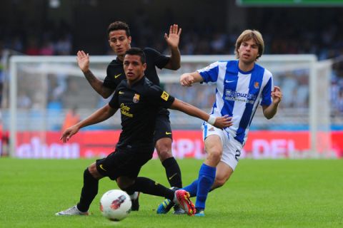 Barcelona's Chiliean forward Alexis Sanchez (bottom L) and Barcelona's midfielder Thiago Alcantara (top L) vie with Real Sociedad's midfielder Asier Illarramandi during a Spanish league football match at Anoeta stadium, in San Sebastian, on September 10, 2011. AFP PHOTO/ RAFA RIVAS (Photo credit should read RAFA RIVAS/AFP/Getty Images)