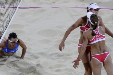 Switzerland's Simone Kuhn reacts with teammate Nadine Sumkehr after winning a point against Greece during a beach volleyball match at the 2012 Summer Olympics, Saturday, July 28, 2012, in London. At left is Greece's Maria Tsiartsiani.  (AP Photo/Dave Martin)