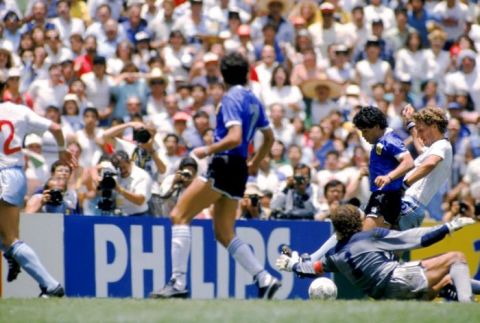 Argentina's Diego Maradona (second right) goes past England's Terry Butcher (right) and Peter Shilton (on floor) to score his second goal of the game