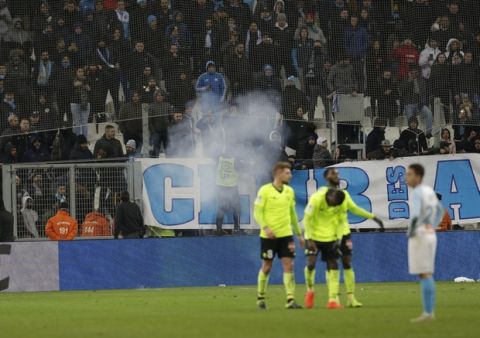 Fans let off a firework after Lille's second goal during a French League One soccer match between Olympique Marseille and Lille at the Stade Velodrome in Marseille, France, Friday, Jan. 25, 2019. (AP Photo/Claude Paris)