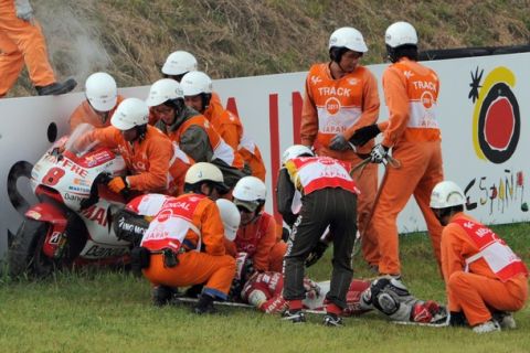 Course marshalls help Ducati rider Hector Barbera of Spain (on ground) into an ambulance after he crashed out on the 12th lap of the MotoGP class race in the Japanese Grand Prix at the Twin Ring Motegi circuit in Motegi on October 2, 2011.      AFP PHOTO / TOSHIFUMI KITAMURA (Photo credit should read TOSHIFUMI KITAMURA/AFP/Getty Images)