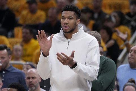 Milwaukee Bucks forward Giannis Antetokounmpo cheers from the bench during the first half in Game 2 against the Indiana Pacers in an NBA basketball first-round playoff series, Friday, April 26, 2024, in Indianapolis. (AP Photo/Michael Conroy)