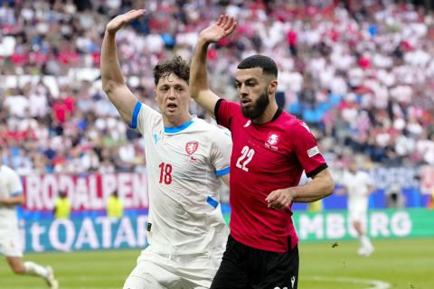 Czech Republic's Ladislav Krejci , left, and Georgia's Georges Mikautadze, right, rise their hands as the challenge for the ball during a Group F match between Georgia and the Czech Republic at the Euro 2024 soccer tournament in Hamburg, Germany, Saturday, June 22, 2024. (AP Photo/Ebrahim Noroozi)