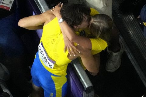 Armand Duplantis, of Sweden, gets a kiss after setting a new world record during the men's pole vault final at the 2024 Summer Olympics, Monday, Aug. 5, 2024, in Saint-Denis, France. (AP Photo/David J. Phillip)