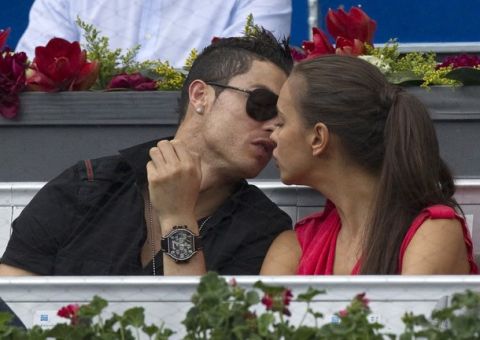 Real Madrid's Cristiano Ronaldo (L) and his girlfriend Irina Shayk kiss during the men's semi-final match between Roger Federer of Switzerland and Janko Tipsarevic of Serbia at the Madrid Open tennis tournament May 12, 2012. REUTERS/Juan Medina(SPAIN - Tags: SPORT TENNIS FASHION SOCCER)