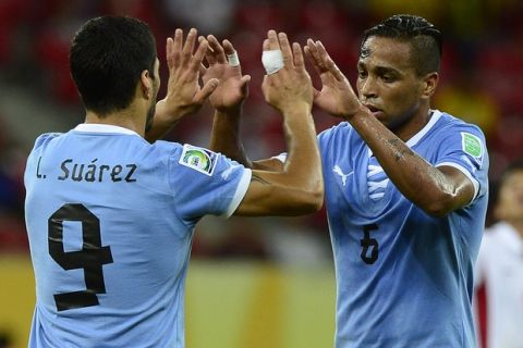 Uruguay's forward Luis Suarez (L) celebartes with teammate Alvaro Pereira after scoring against Tahiti during their FIFA Confederations Cup Brazil 2013 Group B football match, at the Pernambuco Arena in Recife on June 23, 2013.   AFP PHOTO / DANIEL GARCIA        (Photo credit should read DANIEL GARCIA/AFP/Getty Images)