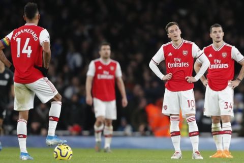 Players of Arsenal stand in the circle after Brighton's Neal Maupay scored his sides second goal during their English Premier League soccer match between Arsenal and Brighton, at the Emirates Stadium in London, Thursday, Dec. 5, 2019. (AP Photo/Frank Augstein)