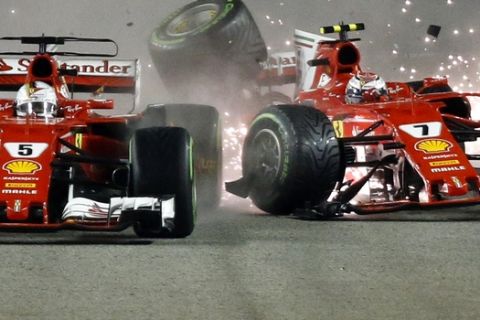 Ferrari driver Kimi Raikkonen, right, of Finland collides with teammate Sebastian Vettel of Germany at the start of the Singapore Formula One Grand Prix on the Marina Bay City Circuit Singapore, Sunday, Sept. 17, 2017. (AP Photo/Yong Teck Lim)