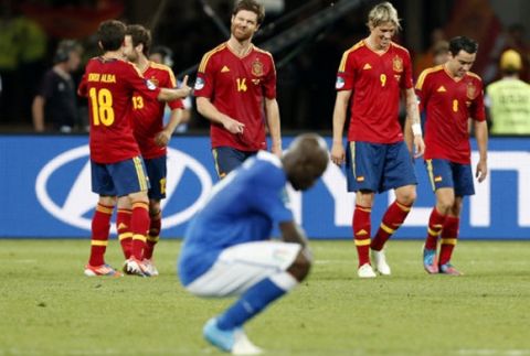 Italy's Mario Balotelli reacts as Spanish players celebrate in background during the Euro 2012 soccer championship final between Spain and Italy in Kiev, Ukraine, Sunday, July 1, 2012. Spain won 4-0. (AP Photo/Jon Super)