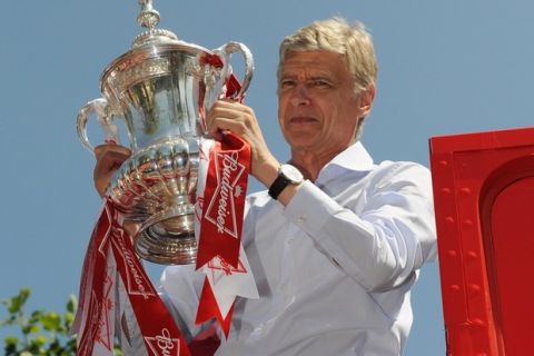 LONDON, ENGLAND - MAY 18: Arsene Wenger the manager of Arsenal FC celebrates with the FA Cup onboard the Arsenal team bus during the Arsenal FA Cup Victory Parade in Islington, London on May 18, 2014 in London, England. (Photo by Steve Bardens/Getty Images)