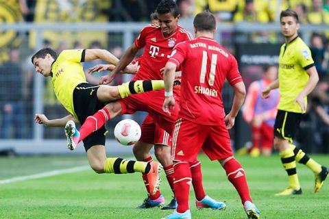 DORTMUND, GERMANY - MAY 04: Robert Lewandowski (L) of Dortmund is challenged by Luiz Gustavo of Muenchen compete for the ball during the Bundesliga match between Borussia Dortmund and FC Bayern Muenchen at Signal Iduna Park on May 4, 2013 in Dortmund, Germany.  (Photo by Joern Pollex/Bongarts/Getty Images)