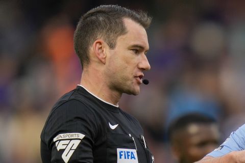 Referee Jarred Gillett, left, discusses with Aston Villa's John McGinn during the English Premier League soccer match between Chelsea and Aston Villa at Stamford Bridge stadium in London, Sunday, Sept. 24, 2023. (AP Photo/Alastair Grant)