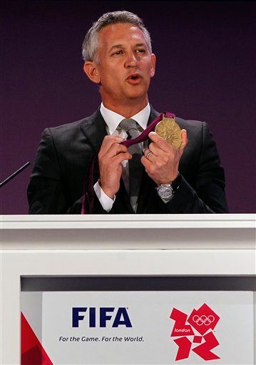 British former footballer Gary Lineker holds up an Olympic gold medal during the draw for the London 2012 Olympic soccer  tournament, at Wembley Stadium in London,  Tuesday, April 24, 2012. (AP Photo/Kirsty Wigglesworth)