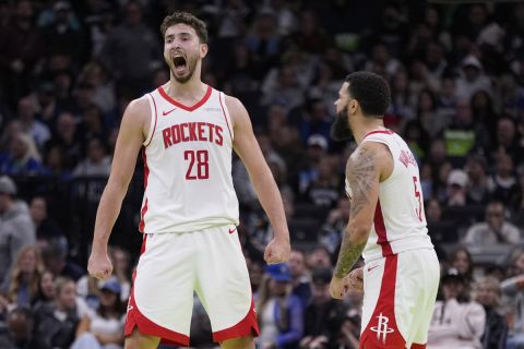 Houston Rockets center Alperen Sengun (28) celebrates next to guard Fred VanVleet (5) after making a shot during overtime of an Emirates NBA cup basketball game against the Minnesota Timberwolves, Tuesday, Nov. 26, 2024, in Minneapolis. (AP Photo/Abbie Parr)