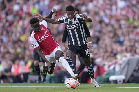 Arsenal's Bukayo Saka, left, and Manchester United's Marcus Rashford fight for the ball during the English Premier League soccer match between Arsenal and Manchester United at Emirates stadium in London, Sunday, Sept. 3, 2023. (AP Photo/Kirsty Wigglesworth)