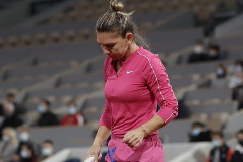 Romania's Simona Halep reacts after missing a shot against Poland's Iga Swiatek in the fourth round match of the French Open tennis tournament at the Roland Garros stadium in Paris, France, Sunday, Oct. 4, 2020. (AP Photo/Alessandra Tarantino)