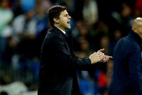 Tottenham coach Mauricio Pochettino applauds next to Real Madrid's head coach Zinedine Zidane during a Group H Champions League soccer match between Real Madrid and Tottenham Hotspur at the Santiago Bernabeu stadium in Madrid, Tuesday Oct. 17, 2017. (AP Photo/Paul White)