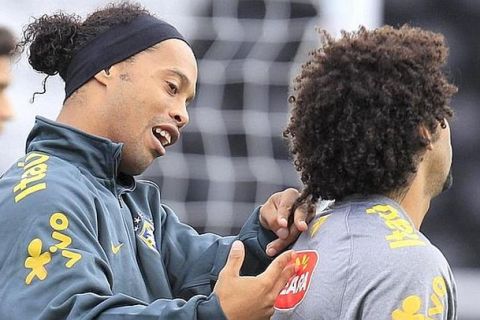 Brazil soccer squad's Ronaldinho, left, jokes with the hair of his teammate Marcelo during a training session at Fulham's Craven Cottage ground in London, Sunday, Sept. 4, 2011 ahead of Monday's international friendly against Ghana.The match between Ghana and Brazil, the five-time world champions and the host nation of the 2014 World Cup finals will take place at Craven Cottage, the London home of Premier League side Fulham. (AP Photo/Lefteris Pitarakis)