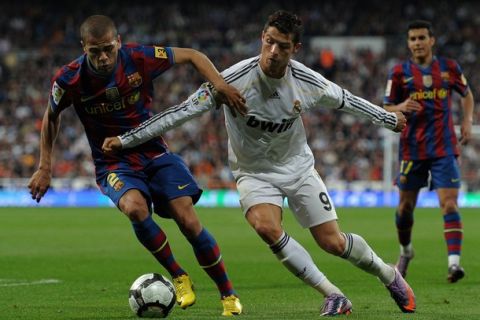 MADRID, SPAIN - APRIL 10:  Cristiano Ronaldo (R) of Real Madrid fights for the ball with Daniel Alves of FC Barcelona during the La Liga match between Real Madrid and Barcelona at the Estadio Santiago Bernabeu on April 10, 2010 in Madrid, Spain. Barcelona won the match 2-0.  (Photo by Jasper Juinen/Getty Images)