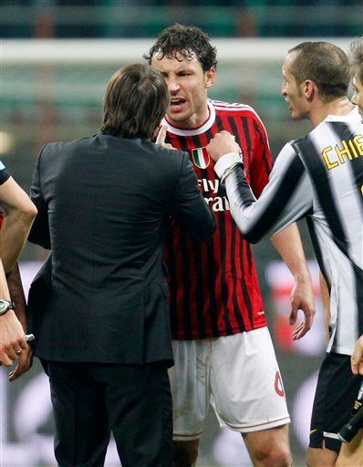 AC Milan midfielder Mark Van Bommel, background, of the Netherlands, argues with Juventus coach Antonio Conte during the Serie A soccer match between AC Milan and Juventus at the San Siro stadium in Milan, Italy, Saturday, Feb. 25, 2012. Alessandro Matri's late goal prevented Juventus from slipping to its first defeat of the season as it snatched a 1-1 draw at Serie A leader AC Milan in a thrilling top-of-the-table clash on Saturday. (AP Photo/Antonio Calanni)