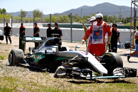 MONTMELO, SPAIN - MAY 15: Marshals around the broken car of Lewis Hamilton of Great Britain and Mercedes GP after he crashed on the first lap during the Spanish Formula One Grand Prix at Circuit de Catalunya on May 15, 2016 in Montmelo, Spain.  (Photo by Clive Mason/Getty Images)