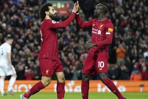 Liverpool's Mohamed Salah, front left, celebrates with Liverpool's Sadio Mane after scoring his side's opening goal during the English Premier League soccer match between Liverpool and Sheffield United at Anfield Stadium, Liverpool, England, Thursday, Jan. 2, 2020. (AP Photo/Jon Super)