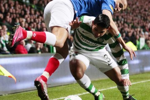 Rangers' Madjid Bougherra falls over Celtic's Emilio Izaguirre (R) as they challenge for the ball during their Scottish Cup soccer match in Glasgow, Scotland March 2, 2011. REUTERS/David Moir (BRITAIN - Tags: SPORT SOCCER)