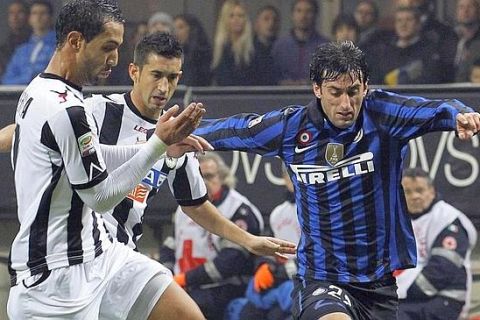 Inter Milan's Diego Milito (R) fights for the ball with Udinese's Al Mouttaqui Benatia (17) during their Italian Serie A soccer match at the San Siro stadium in Milan December 3, 2011. REUTERS/Alessandro Garofalo (ITALY - Tags: SPORT SOCCER)