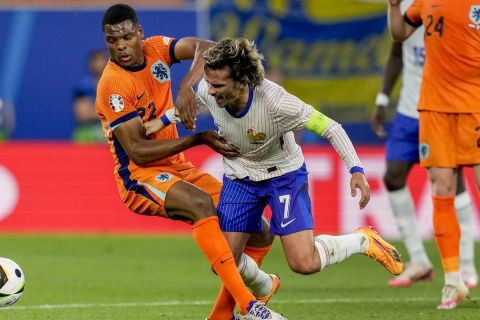 Denzel Dumfries of the Netherlands, left, and Antoine Griezmann of France challenge for the ball during a Group D match between the Netherlands and France at the Euro 2024 soccer tournament in Leipzig, Germany, Friday, June 21, 2024. (AP Photo/Antonio Calanni)