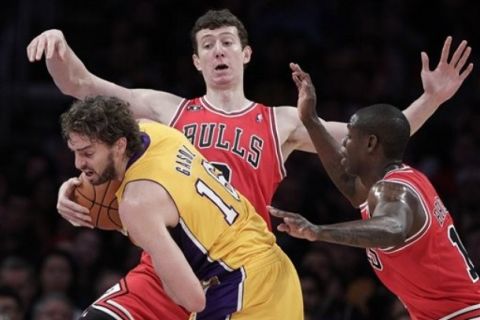 Los Angeles Lakers forward Pau Gasol, left, of Spain, protects the ball from Chicago Bulls' Ronnie Brewer, right, and Omer Asik during the first half of an NBA basketball game in Los Angeles, Tuesday, Nov. 23, 2010. (AP Photo/Jae C. Hong)