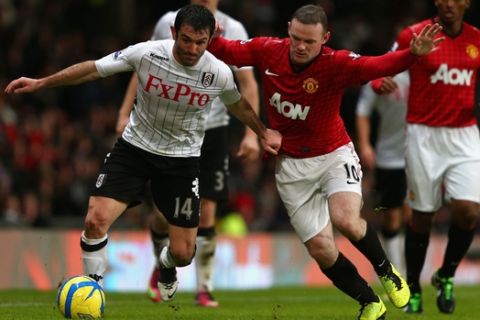 MANCHESTER, ENGLAND - JANUARY 26:  Giorgos Karagounis of Fulham battles for the ball with Wayne Rooney of Manchester United during the FA Cup with Budweiser Fourth Round match between Manchester United and Fulham at Old Trafford on January 26, 2013 in Manchester, England.  (Photo by Clive Mason/Getty Images)