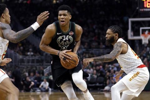 Milwaukee Bucks' Giannis Antetokounmpo (34) drives between Atlanta Hawks' John Collins and DeAndre' Bembry during the second half of an NBA basketball game Friday, Jan. 4, 2019, in Milwaukee. (AP Photo/Aaron Gash)