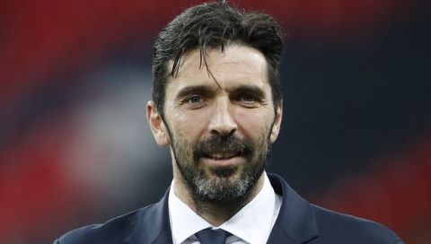 Italian's goalkeeper Gianluigi Buffon holds a cup during a walkaround at Wembley Stadium, a day ahead of the international friendly soccer match between England and Italy in London, Monday, March 26, 2018. (AP Photo/Frank Augstein)