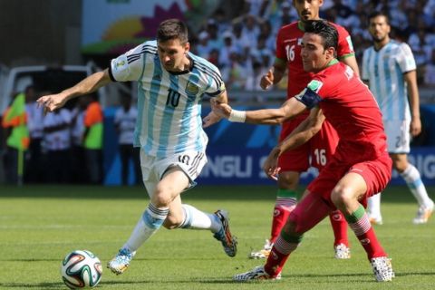 BELO HORIZONTE, BRAZIL - JUNE 21: Lionel Messi of Argentina and Javad Nekounam of Iran in action during the 2014 FIFA World Cup Brazil Group F match between Argentina and Iran at Estadio Mineirao on June 21, 2014 in Belo Horizonte, Brazil. (Photo by Jean Catuffe/Getty Images)