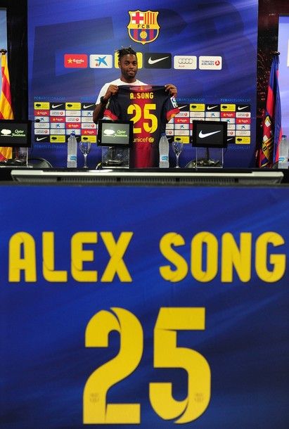 Barcelona's new signing Cameroonian midfielder Alex Song poses with his new FC Barcelona jersey on August 21, 2012 at Camp Nou stadium in Barcelona. Song is the latest star player to leave the Emirates Stadium after Barcelona agreed to pay £15 million (19 million euros) for Song, who will have a release clause of 80 million euros inserted in his contract. AFP PHOTO/LLUIS GENE.        (Photo credit should read LLUIS GENE/AFP/GettyImages)