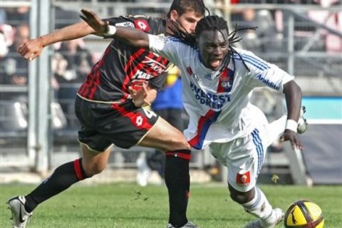 Lyon's Bafetimbi Gomis of France, right, challenges for the ball with Nice's Nemanja Pejcinovic, during their French League One soccer match, Sunday, April 3, 2011, in Nice stadium, southeastern France. (AP Photo/Lionel Cironneau)