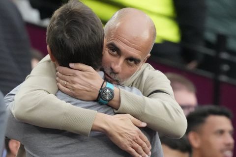 Manchester City's head coach Pep Guardiola, right, hugs with West Ham's head coach Julen Lopetegui ahead the English Premier League soccer match between West Ham United and Manchester City at the London Stadium in London, England, Saturday, Aug. 31, 2024. (AP Photo/Frank Augstein)