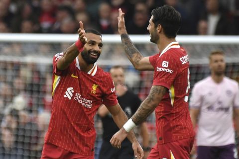 Liverpool's Mohamed Salah celebrates with Liverpool's Dominik Szoboszlai, right, after scoring his side's second goal during the English Premier League soccer match between Liverpool and Brentford at Anfield Stadium, Liverpool, England, Sunday, Aug. 25, 2024. (AP Photo/Rui Vieira)