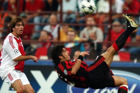 A.C. Milan Gennaro Gattuso, right, tries an acrobatic kicks as  Ajax Brazilian midfielder Maxwell looks on during a group H Champions League soccer match at the San Siro stadium in Milan, Italy, Tuesday, Sept.16, 2003. (AP Photo/Luca Bruno)