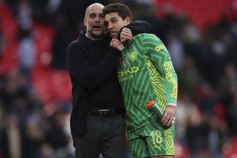 Manchester City's head coach Pep Guardiola hugs Manchester City's goalkeeper Stefan Ortega on full time of the English FA Cup semifinal soccer match between Manchester City and Chelsea at Wembley stadium in London, Saturday, April 20, 2024. Manchester City won 1-0. (AP Photo/Ian Walton)