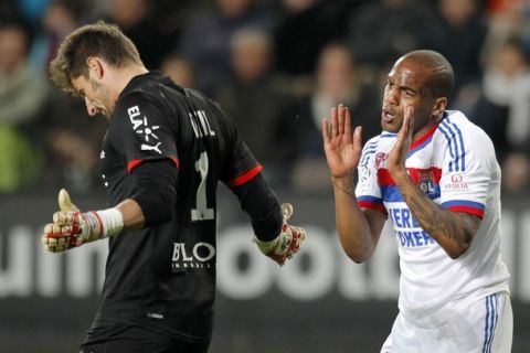 Olympique Lyon Jimmy Briand (R) reacts near Stade Rennes goalkeeper Benoit Costil during their French Ligue 1 soccer match at the Route de Lorient stadium in Rennes, April 1, 2012.  REUTERS/Stephane Mahe (FRANCE - Tags: SPORT SOCCER)