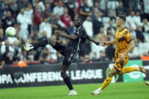 Besiktas' Omar Colley, left, shoots the ball next to Lugano's Zan Celar during the Europa Conference League, group D soccer match between Besiktas and Lugano, in Istanbul, Turkey, Thursday Oct. 5, 2023. (AP Photo/Francisco Seco)