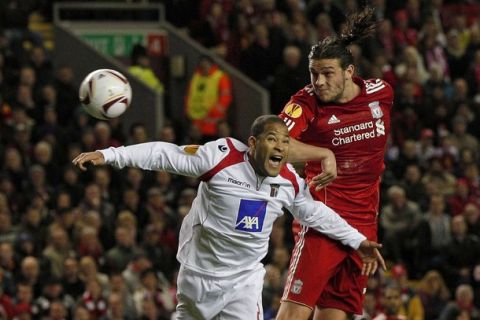 Braga's Alberto Junior Rodriguez (L) challenges Liverpool's Andy Carroll in the air during their Europa League last 16, second leg soccer match at Anfield in Liverpool, northern England, March 17, 2011.  REUTERS/Phil Noble (BRITAIN - Tags: SPORT SOCCER)