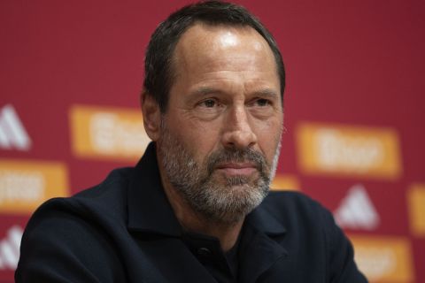 Ajax trainer John van 't Schip listens during a news conference in Amsterdam, Netherlands, Friday, Jan. 19, 2024. The lucrative Saudi soccer league lost one of its high-profile players when England midfielder Jordan Henderson quit Al-Ettifaq to sign for struggling Dutch powerhouse Ajax. (AP Photo/Peter Dejong)