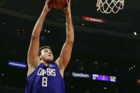 Los Angeles Clippers' Danilo Gallinari (8) dunks in front of Dallas Mavericks' Luka Doncic (77) during the first half of an NBA basketball game Thursday, Dec. 20, 2018, in Los Angeles. (AP Photo/Marcio Jose Sanchez)