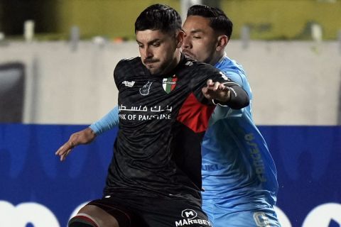 Jose Bizama of Chile's Palestino, left, fights for the ball with Carmelo Algaranaz of Bolivia's Bolivar during a Copa Libertadores Group E soccer match at Hernando Siles stadium in La Paz, Bolivia, Tuesday, May 28, 2024. (AP Photo/Juan Karita)